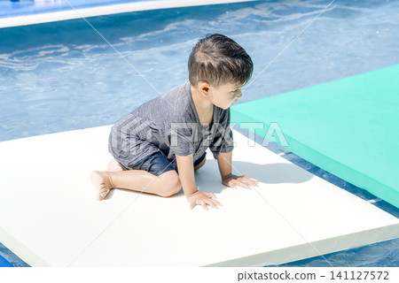Child Splashing in Water Playground Pool 141127572