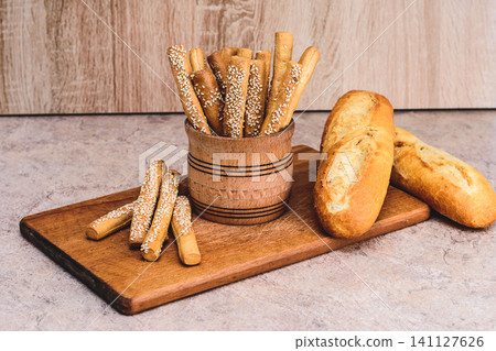 French baguettes. Fresh crispbread. Bread background. Different breed on wooden background. French baguettes. Fresh crispbread. Bread background. Different breed on wooden background. 141127626