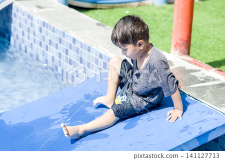 Child Relaxing on Green Grass Outdoors 141127713