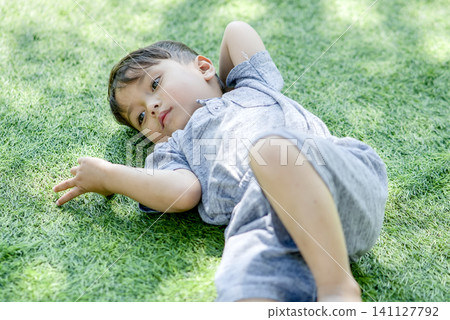 asian boy lying on grass asian boy lying on grass 141127792