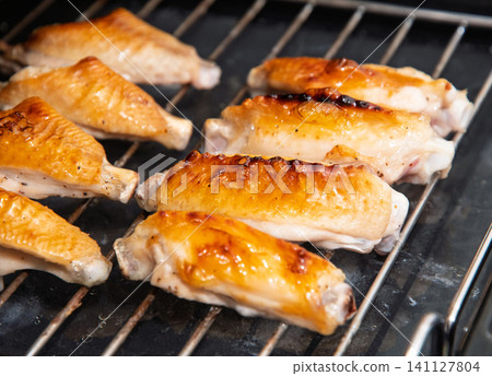 Grilled chicken wings during cooking Grilled chicken wings during cooking 141127804