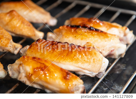 Grilled chicken wings during cooking Grilled chicken wings during cooking 141127809