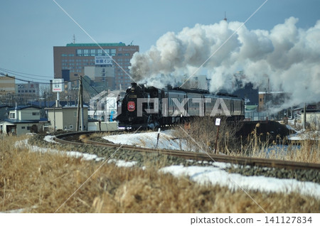 The SL Winter Marshland train powerfully runs through the winter streets of Kushiro, accompanied by plumes of white smoke. The SL Winter Marshland train powerfully runs through the winter streets of Kushiro, accompanied by plumes of white smoke. 141127834