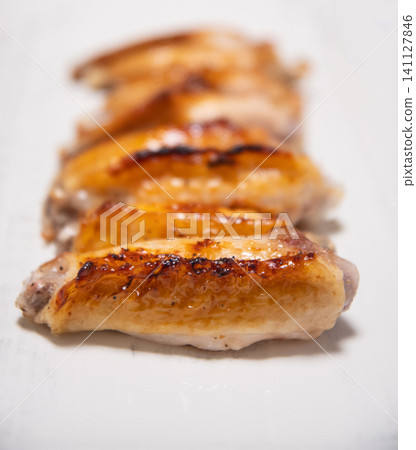 Grilled chicken wings served on a white square plate Grilled chicken wings served on a white square plate 141127846