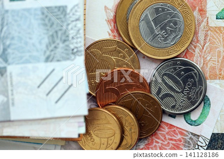 Brazilian real money bills and centavo coins pile on table. Brazil coins on banknotes of BRL currency close up. Concept of business, taxes and banking in Brazil Brazilian real money bills and centavo coins pile on table. Brazil coins on banknotes of BRL currency close up. Concept of business, taxes and banking in Brazil 141128186