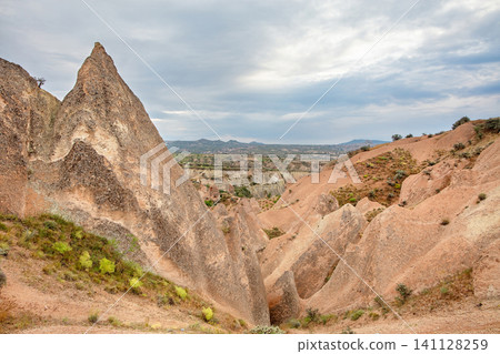 View of rocky landscape with large formations under cloudy sky in a desert area during daytime View of rocky landscape with large formations under cloudy sky in a desert area during daytime 141128259