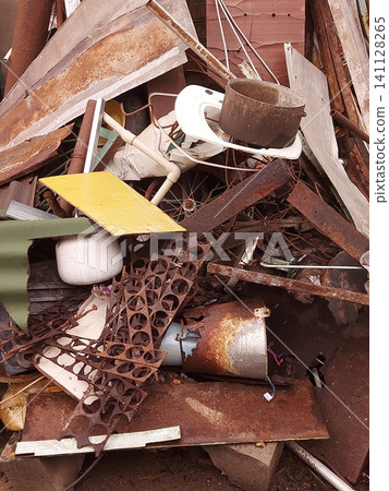 Pile of rusty scrap metal with discarded steel sheets, pipes, wire, household items and industrial waste at a recycling yard. Concept of metal recycling, waste management, environmental pollution, ind 141128265