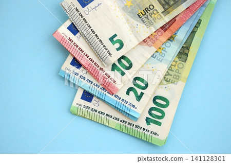 Big amount of european euro currency money notes on blue color table close up Big amount of european euro currency money notes on blue color table close up 141128301