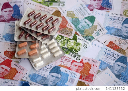 Pakistan rupees banknotes and medicine pills. Pakistan money bills with drugs close up Pakistan rupees banknotes and medicine pills. Pakistan money bills with drugs close up 141128332