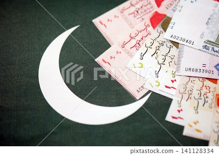 Pakistan rupees banknotes on Pakistani flag background. The current Pakistan money bills Pakistan rupees banknotes on Pakistani flag background. The current Pakistan money bills 141128334