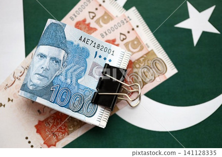 Pakistan rupees banknotes on Pakistani flag. The current Pakistan money bills Pakistan rupees banknotes on Pakistani flag. The current Pakistan money bills 141128335