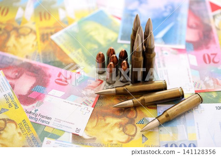 Swiss franc banknotes and bullets. The current francs money bills and ammo lies on table 141128356