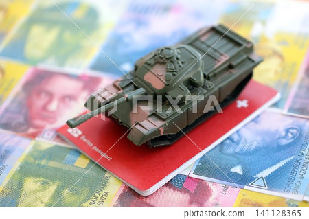Swiss franc banknotes and toy tank on passport. The current francs money bills and tank on pass Swiss franc banknotes and toy tank on passport. The current francs money bills and tank on pass 141128365