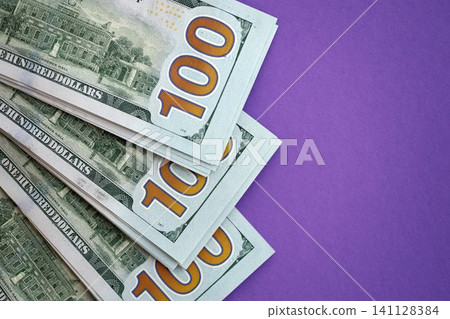 Big amount of United States hundred dollar bills on purple background Big amount of United States hundred dollar bills on purple background 141128384