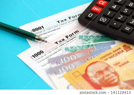 Nigerian naira money bills and calculator with tax form. Taxation and accounting concept Nigerian naira money bills and calculator with tax form. Taxation and accounting concept 141128413