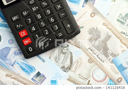 United Arab Emirates dirham currency money bills and calculator. The concept of taxation and money count United Arab Emirates dirham currency money bills and calculator. The concept of taxation and money count 141128416