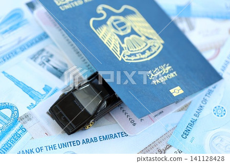 United Arab Emirates dirham currency money bills and car with passport. The concept of car ownership United Arab Emirates dirham currency money bills and car with passport. The concept of car ownership 141128428