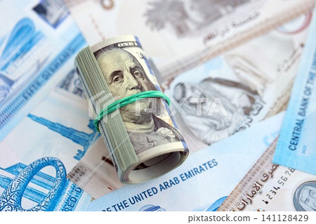 United Arab Emirates dirham currency money bills and bunch of us dollar banknotes. The concept of economics and currency exchange United Arab Emirates dirham currency money bills and bunch of us dollar banknotes. The concept of economics and currency exchange 141128429