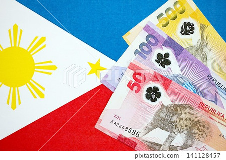 Philippines peso currency money bills lies on flag. The concept of business and investment Philippines peso currency money bills lies on flag. The concept of business and investment 141128457