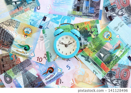 Kuwaiti dinar currency money bills and alarm clock. The concept of time management and income Kuwaiti dinar currency money bills and alarm clock. The concept of time management and income 141128496