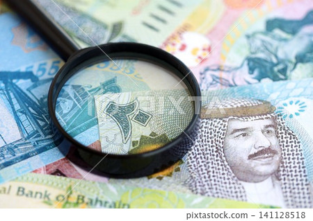 Bahraini dinar currency money bills and magnifying glass. The concept of financial monitoring Bahraini dinar currency money bills and magnifying glass. The concept of financial monitoring 141128518