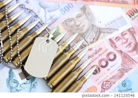Thai baht currency money bills and rifle bullets with dogtag. The concept of warfare and army Thai baht currency money bills and rifle bullets with dogtag. The concept of warfare and army 141128546