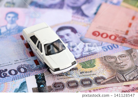 Thai baht currency money bills and toy car. The concept of car ownership Thai baht currency money bills and toy car. The concept of car ownership 141128547