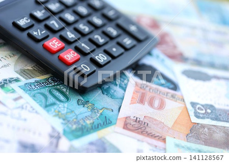 Egyptian pound currency money bills and calculator. The concept of taxation and money count Egyptian pound currency money bills and calculator. The concept of taxation and money count 141128567