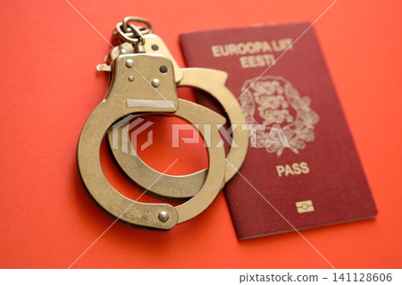 Estonia passport with police handcuffs on table. Criminal level and arrests in Europe Estonia passport with police handcuffs on table. Criminal level and arrests in Europe 141128606
