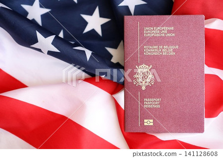 Belgium passport on big waving flag of United States of America. US Visa and immigration Belgium passport on big waving flag of United States of America. US Visa and immigration 141128608