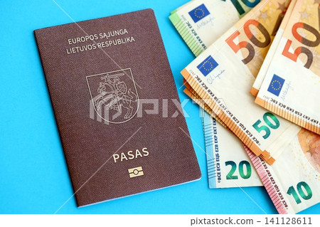 Lithuania passport lies with euro money banknotes on blue background. Salary and pension in Europe Lithuania passport lies with euro money banknotes on blue background. Salary and pension in Europe 141128611