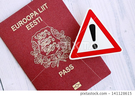 Estonia passport with exclamation sign on wooden table. Problems with citizenship in Europe Estonia passport with exclamation sign on wooden table. Problems with citizenship in Europe 141128615