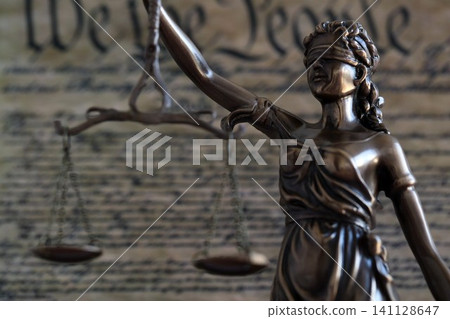 Lady Justice and background of US Constitution page. Lawsuit and judgement in US Lady Justice and background of US Constitution page. Lawsuit and judgement in US 141128647