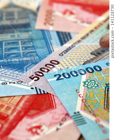 Uzbek som money bills pile on table. Uzbekistan banknotes of UZN currency close up Uzbek som money bills pile on table. Uzbekistan banknotes of UZN currency close up 141128730