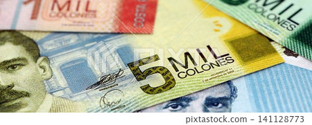 Costa Rican old colon money bills pile on table. Costa Rica banknotes of CRC currency close up Costa Rican old colon money bills pile on table. Costa Rica banknotes of CRC currency close up 141128773