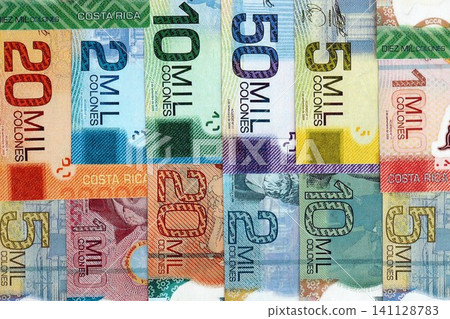 Costa Rican colon money bills pile on table. Costa Rica banknotes of CRC currency close up Costa Rican colon money bills pile on table. Costa Rica banknotes of CRC currency close up 141128783