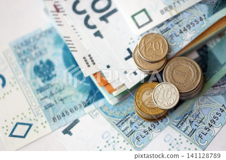 Polish zloty money bills and grosz coins pile on table. Poland coins on banknotes of PLN currency Polish zloty money bills and grosz coins pile on table. Poland coins on banknotes of PLN currency 141128789
