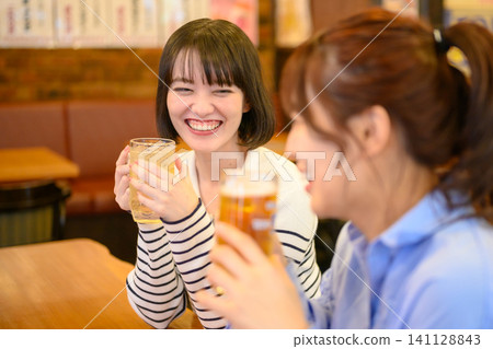 Two young Japanese women toast each other. Two young Japanese women toast each other. 141128843