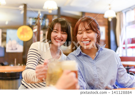 Japanese women toast with beer and laugh. Japanese women toast with beer and laugh. 141128884