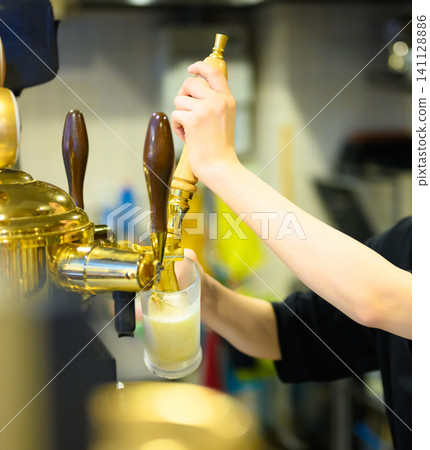Pour beer from the beer server 141128886