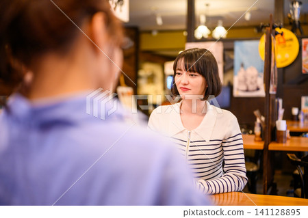 A young Japanese woman talking in a restaurant A young Japanese woman talking in a restaurant 141128895