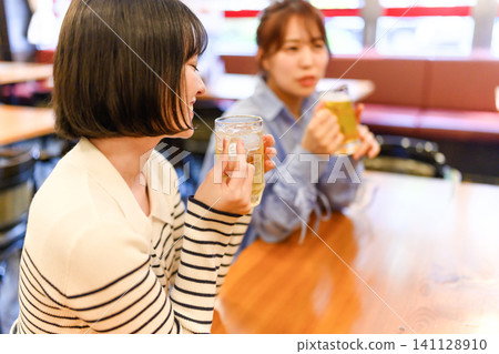 Two women drinking beer Two women drinking beer 141128910
