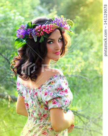 A girl with a wreath of wildflowers, a portrait in the forest. Forest landscape. Summer mood, vertical photo A girl with a wreath of wildflowers, a portrait in the forest. Forest landscape. Summer mood, vertical photo 141129078