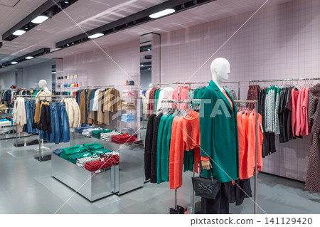 Fashion boutique interior featuring a styled mannequin and colorful clothing racks Fashion boutique interior featuring a styled mannequin and colorful clothing racks 141129420