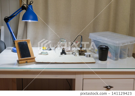 Soldering iron and tools on the desktop. Solderer workplace. Engineer's desk. STEM education. DIY school science and technology project. Hobbies are electronics. Hardware, technician and technology. 141129423