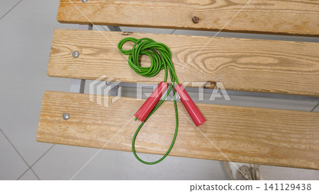 Skipping rope. Fitness, Dieting, healthy lifestyle Concept, Sport Item exercise accessories, running shoes, Lockers in gym locker room background. Copy space. Indoor workout. Wellness exercise. Skipping rope. Fitness, Dieting, healthy lifestyle Concept, Sport Item exercise accessories, running shoes, Lockers in gym locker room background. Copy space. Indoor workout. Wellness exercise. 141129438
