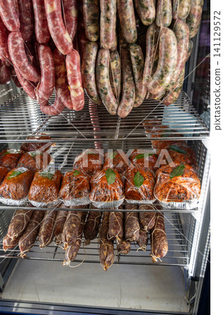 Naples, italy. December 27, 2024. Butcher shop displaying fresh and cured italian sausages, salami, and prepared meats, showcasing traditional neapolitan deli products Naples, italy. December 27, 2024. Butcher shop displaying fresh and cured italian sausages, salami, and prepared meats, showcasing traditional neapolitan deli products 141129572