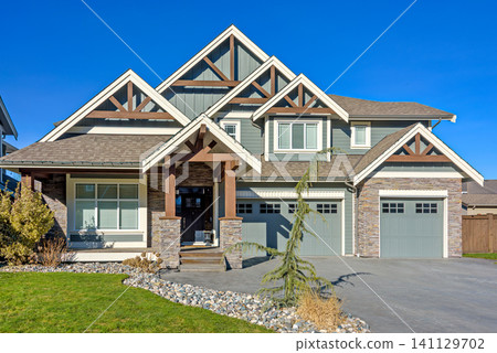 Contemporary Suburban Family Home with Stone Facade and Blue Sky Background Contemporary Suburban Family Home with Stone Facade and Blue Sky Background 141129702