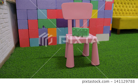 Comfortable vivid multicolored kids playroom or kindergarten nursery interior design with kid toys, play space. Bright and spacious colorful game room for children with plastic educational blocks toys Comfortable vivid multicolored kids playroom or kindergarten nursery interior design with kid toys, play space. Bright and spacious colorful game room for children with plastic educational blocks toys 141129788