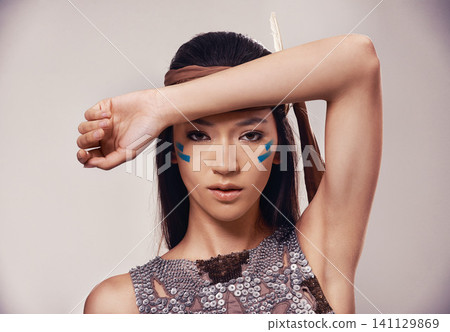 Portrait, woman and Native American girl in studio with warrior makeup, confidence and tribe style. Indigenous fashion, face paint and model in First Nations clothes on white background with culture Portrait, woman and Native American girl in studio with warrior makeup, confidence and tribe style. Indigenous fashion, face paint and model in First Nations clothes on white background with culture 141129869